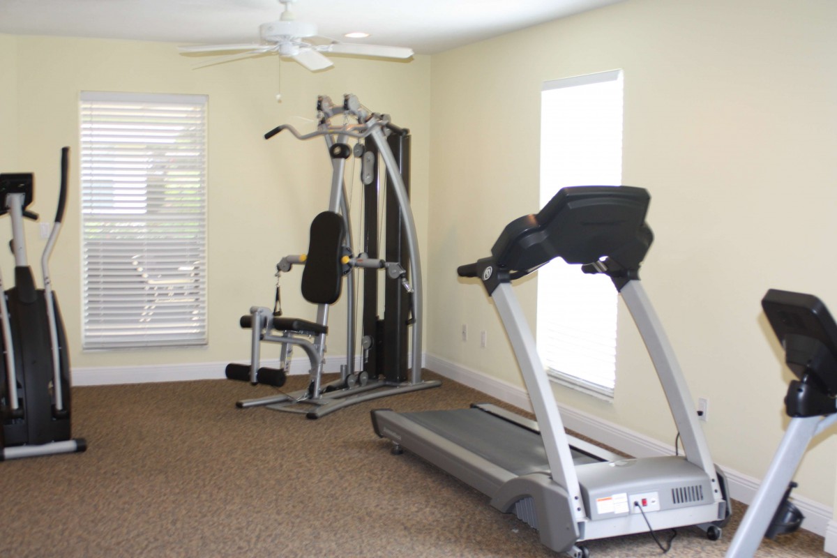 A compact home gym featuring a treadmill and multi-gym machine.