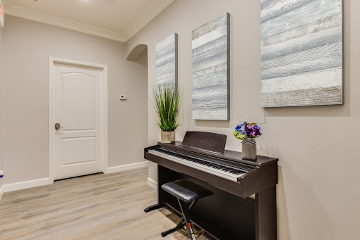 A modern entrance featuring a digital piano, elegant artwork on the walls, and a touch of greenery.
