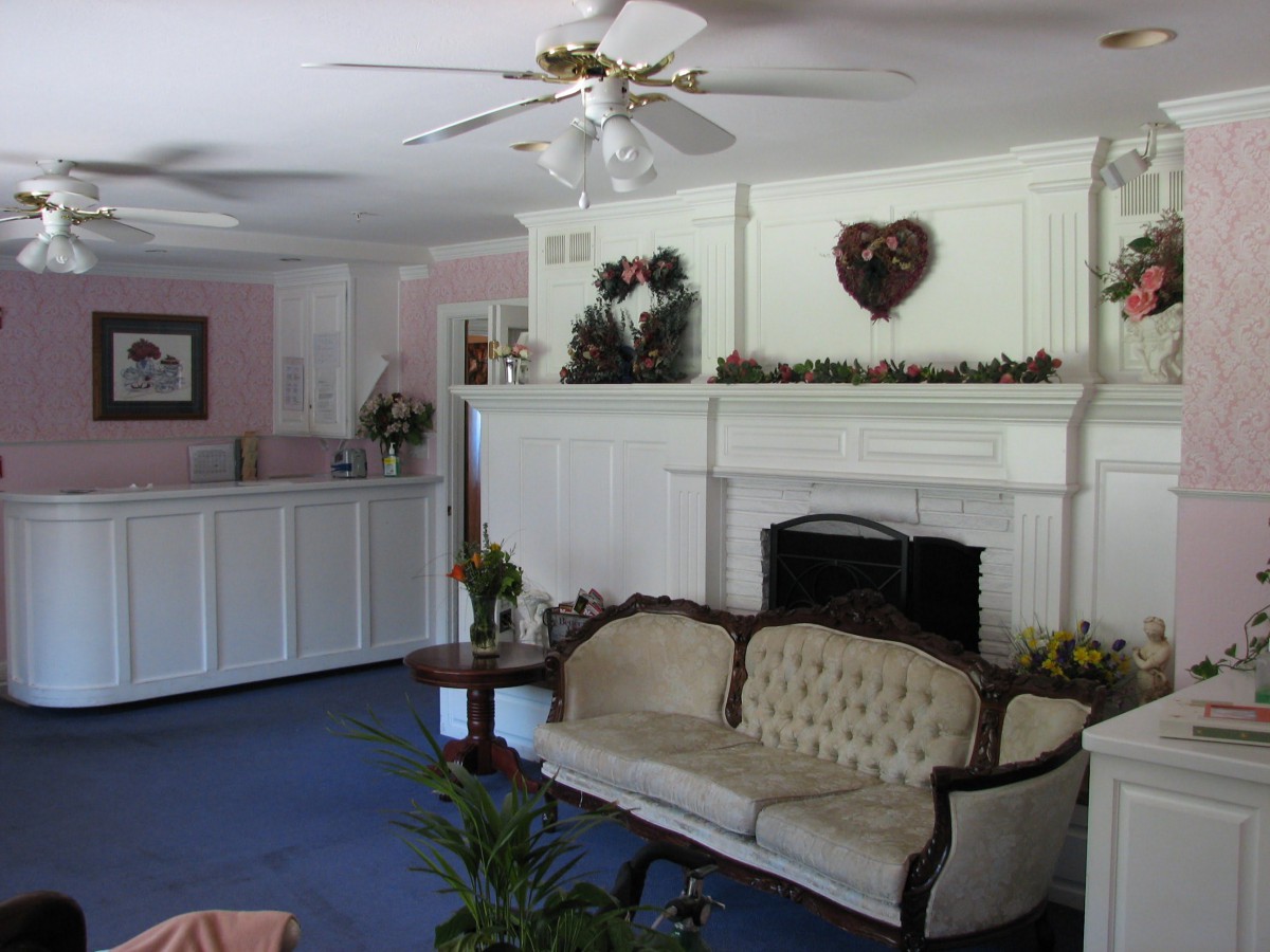 A traditional living room with a sofa, fireplace, and ceiling fan.