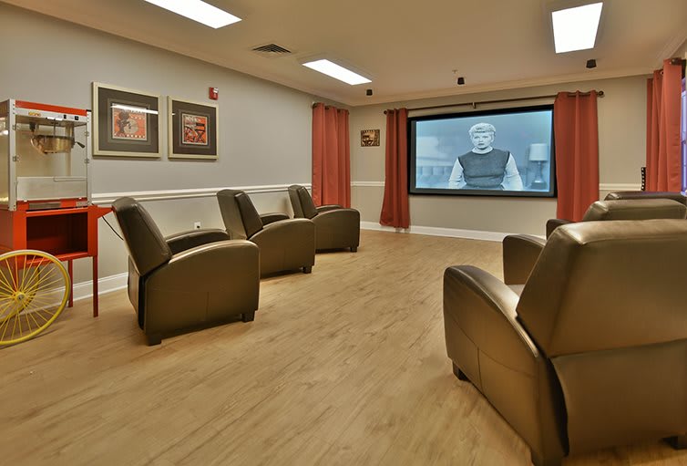 A cozy home theater room with comfortable seating and a large screen for viewing.
