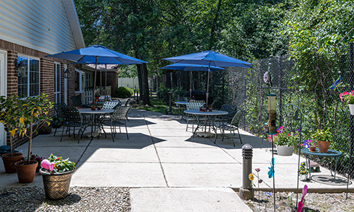 A cozy outdoor patio area with tables and blue umbrellas, perfect for relaxation.