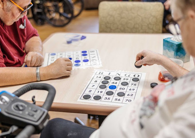 Seniors playing bingo at a table in a leisure setting.