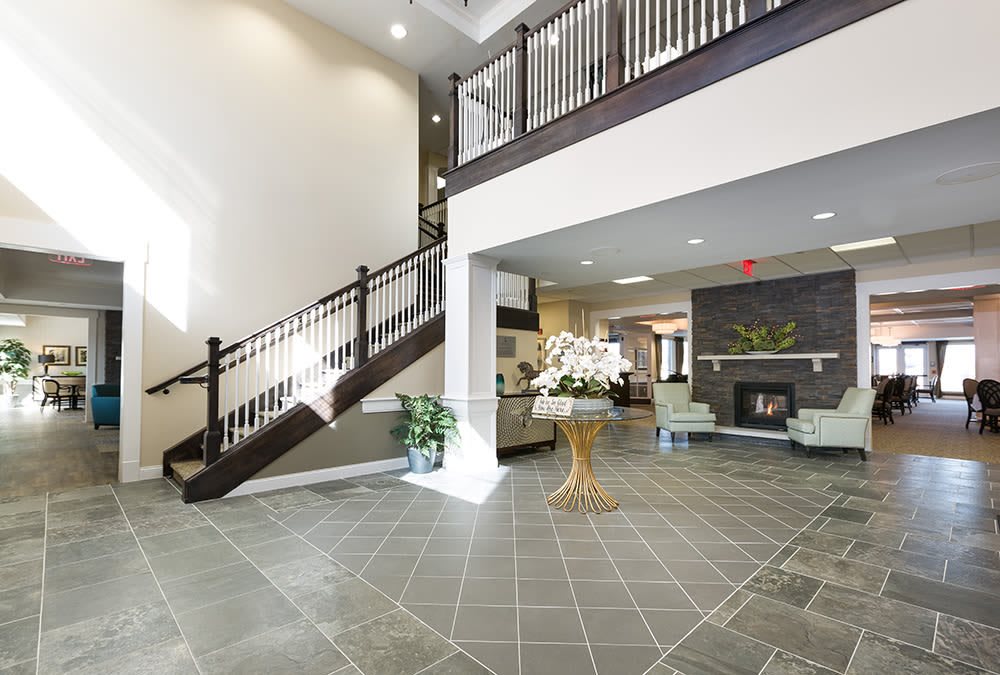 A spacious and modern lobby with a staircase and comfortable seating.
