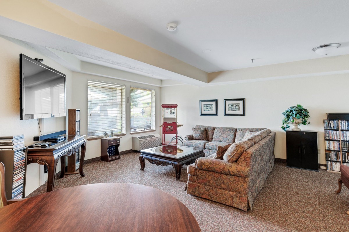 A cozy living room with a sectional sofa, coffee table, and large windows.