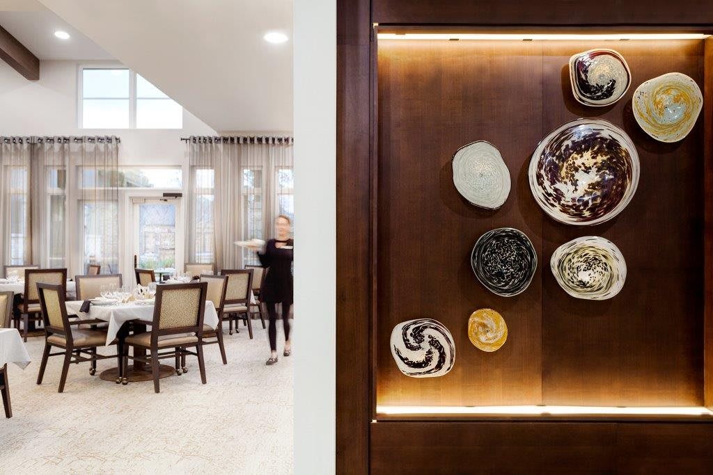 A modern dining room featuring artistic wall plates and elegant furniture.