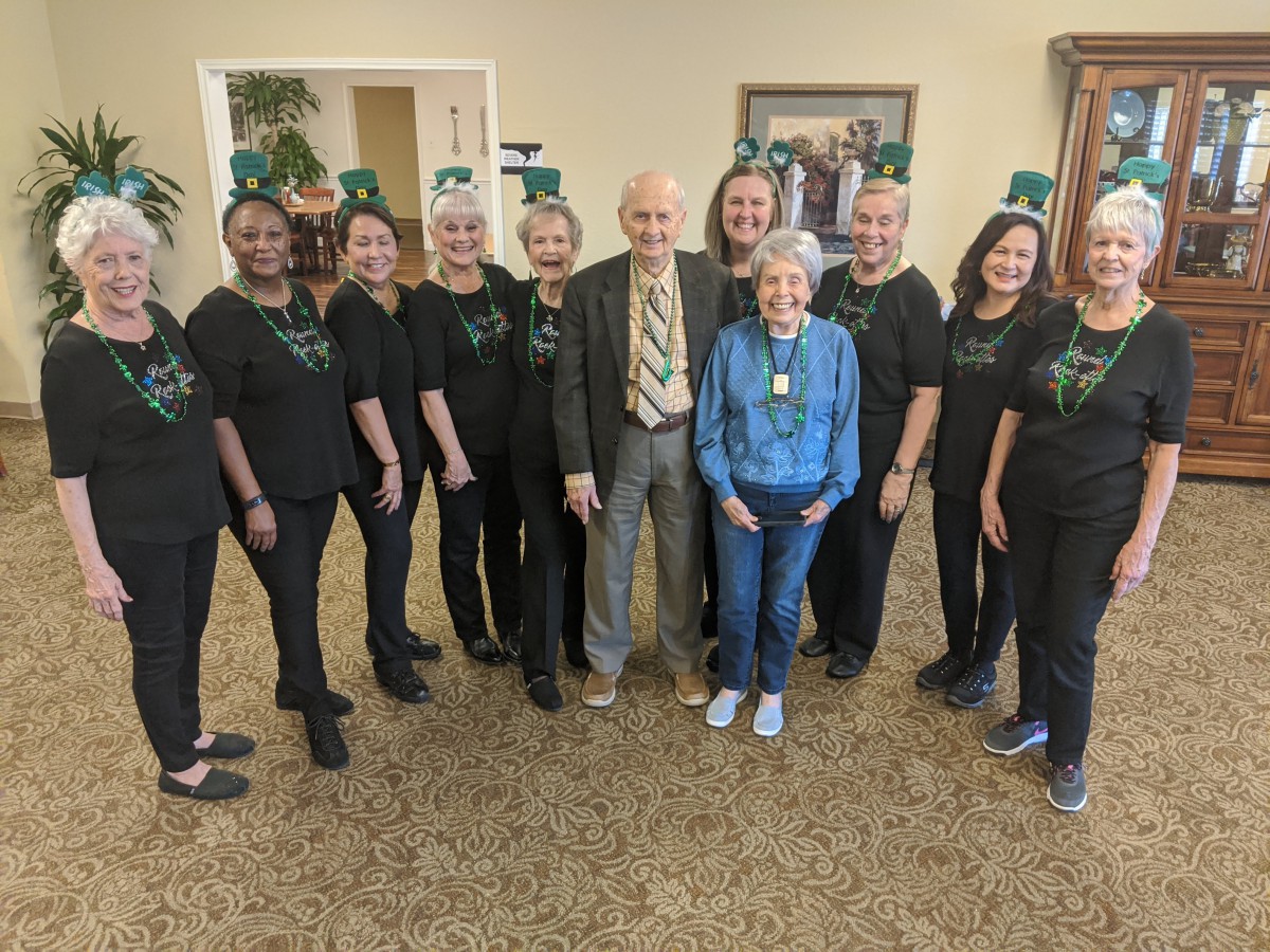 A group of seniors celebrating St. Patrick's Day with festive hats.