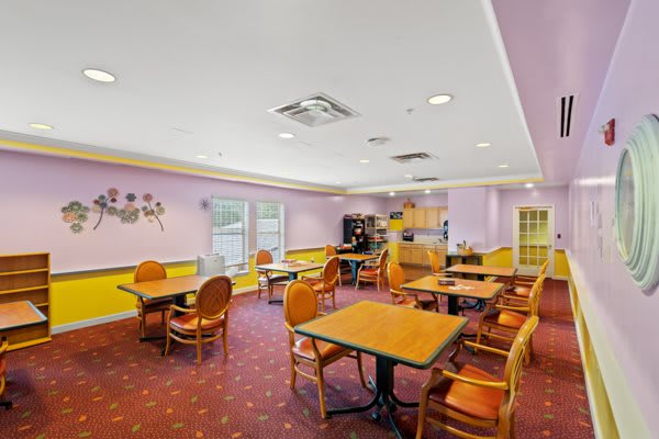 A cozy indoor dining area with tables and chairs, featuring a warm color scheme.