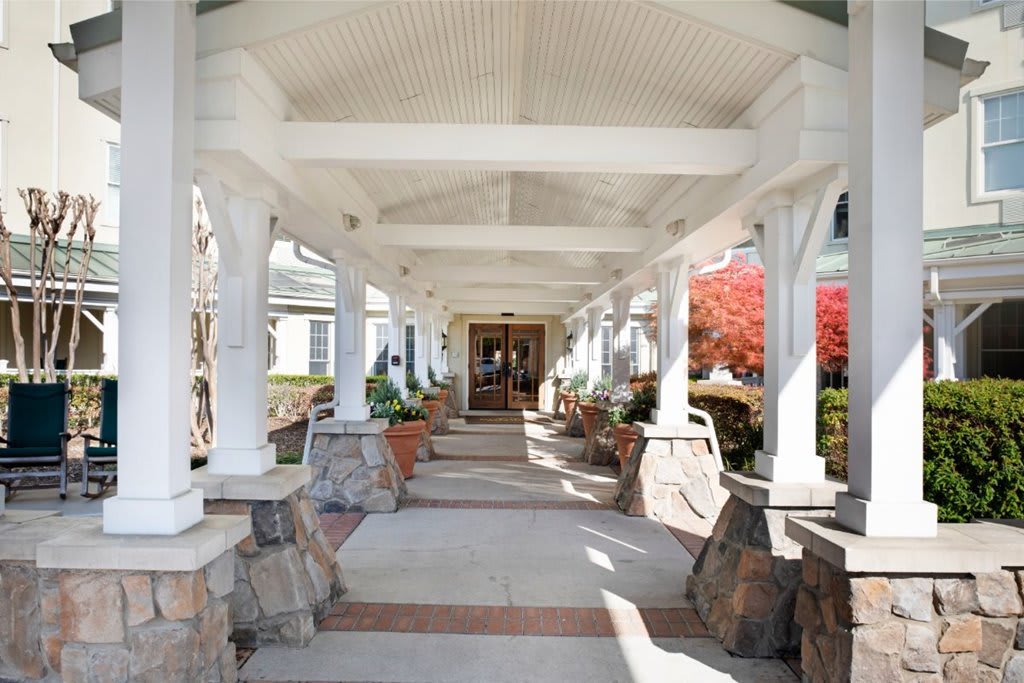 A covered walkway with stone pillars leading to an entrance.