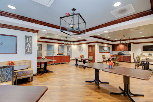 A spacious and elegantly designed dining area featuring modern furniture and warm lighting.