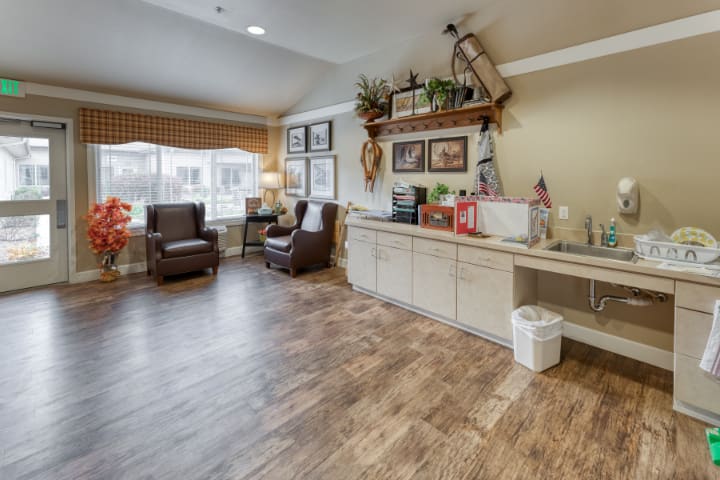 A cozy living room with wood flooring, comfortable seating, and decorative elements.