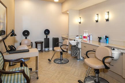 A modern hair salon interior with styling chairs and equipment.