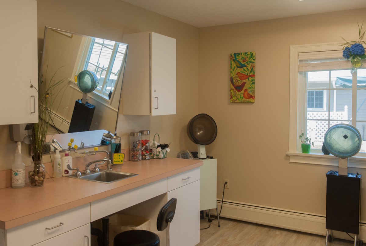 A tidy and minimalist office space with a desk, mirror, and window.