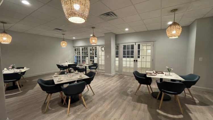 A modern dining area with stylish lighting and wood flooring.