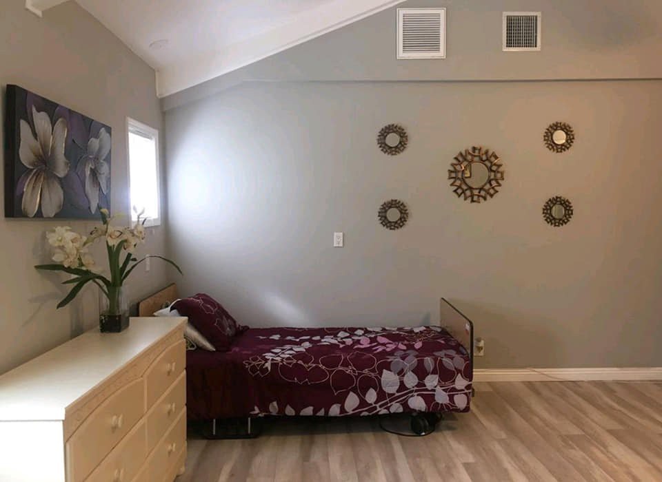A minimalist bedroom with a single bed, modern wall art, and a dresser.