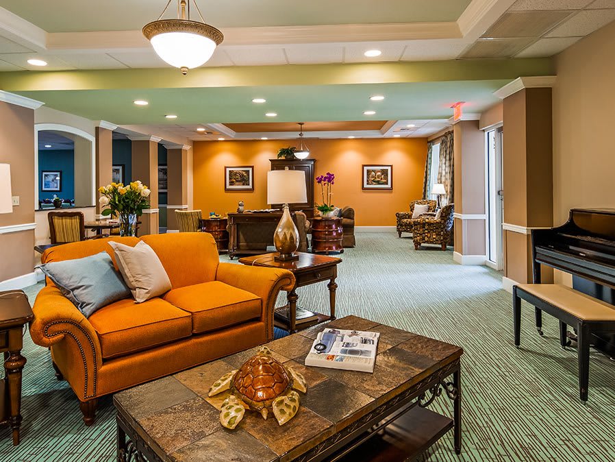 A warmly decorated living room featuring an orange sofa and elegant furnishings.