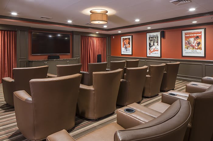 A cozy home theater with comfortable leather seating and a large projector screen, perfect for watching movies.