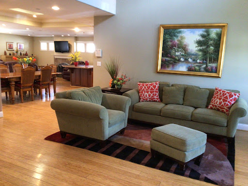 A spacious and inviting living room featuring a comfortable sofa, ottoman, and decorative artwork.