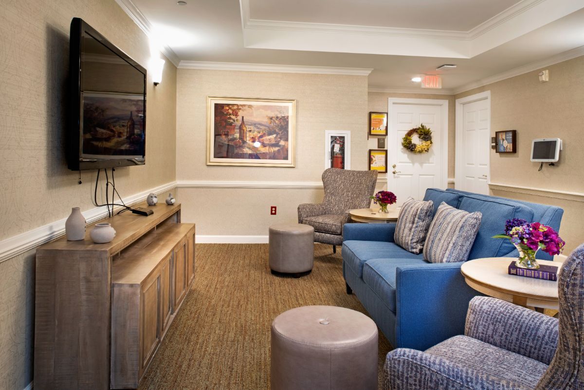 A cozy living room with comfortable seating, a television, and decorative artwork on the walls.