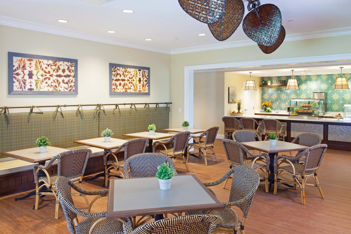A cozy dining area with wicker furniture and decorative artwork on the walls.