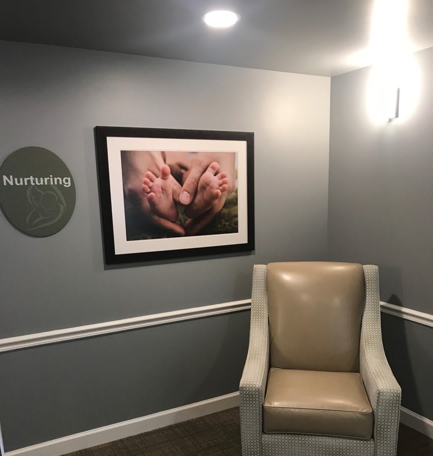 A cozy hallway with a comfortable chair and framed artwork on the wall.