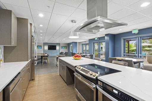 A modern kitchen featuring an island with a cooktop, stainless steel appliances, and contemporary decor.