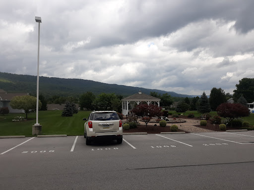 A parked car in a lot with a scenic view of mountains under a cloudy sky.