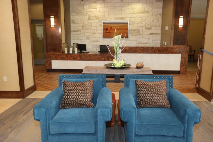 A modern lobby with blue chairs and a sleek reception desk.
