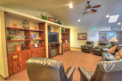 A cozy living room area featuring comfortable recliners and wooden shelves with a television, creating an inviting atmosphere.