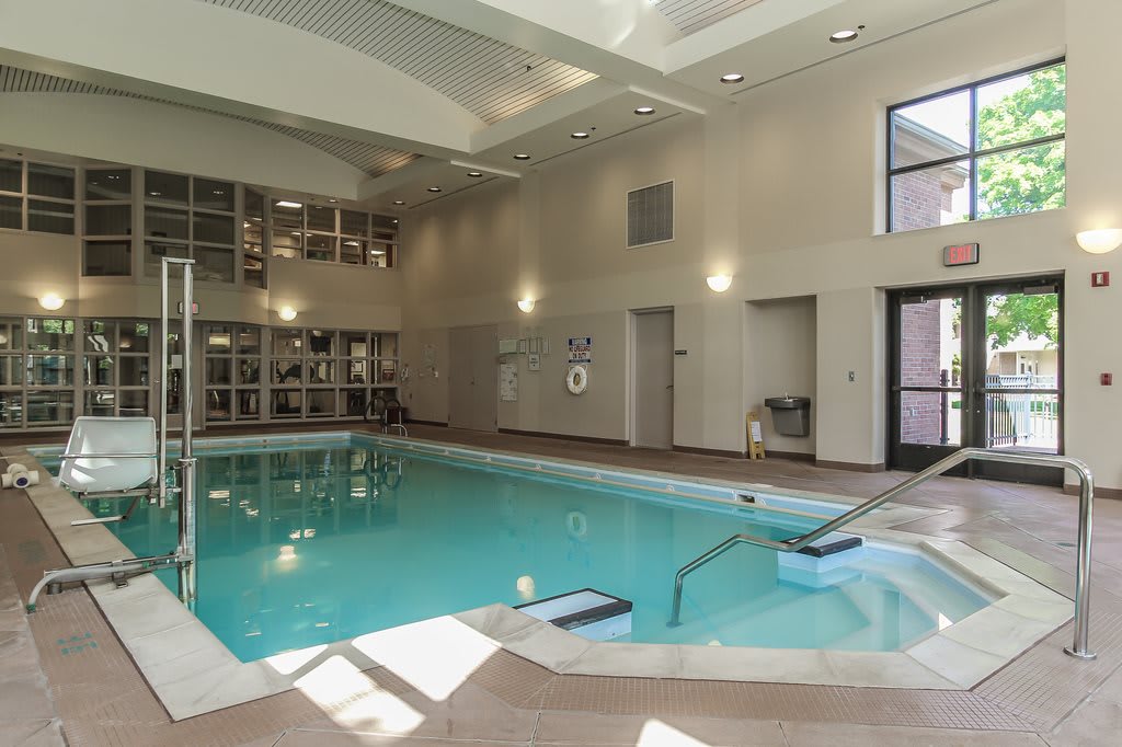 An inviting indoor swimming pool with modern facilities and natural lighting.