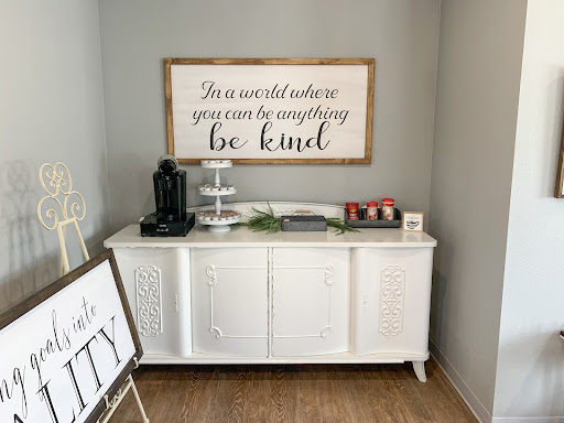 A beautifully decorated console table featuring a motivational wall art piece that encourages kindness.