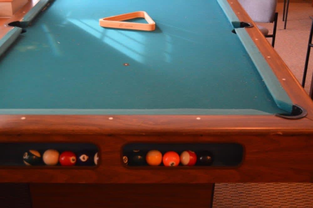 A pool table with a triangle rack and balls ready for play.