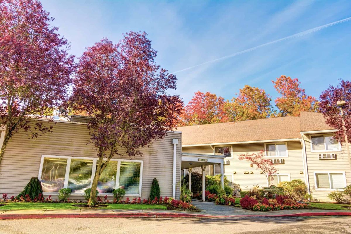 A building surrounded by colorful autumn trees under a clear blue sky.