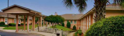 A serene view of a well-maintained building surrounded by greenery.