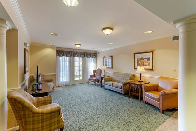 A cozy living room interior with sofas, chairs, and warm lighting.