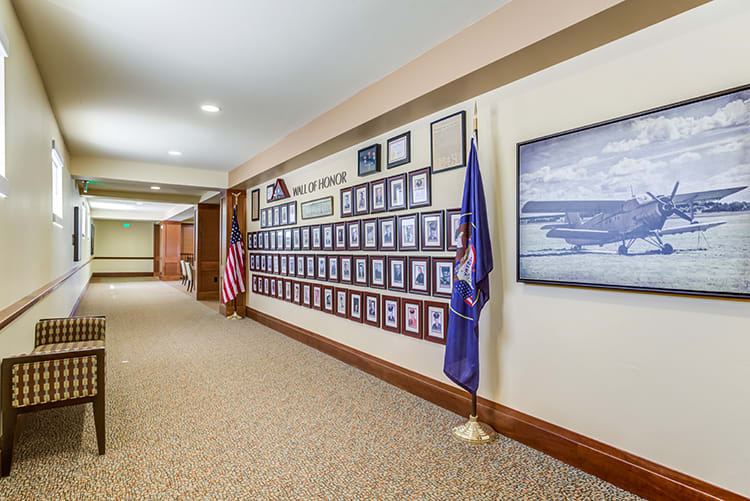 A hallway with a display of framed photographs and flags.