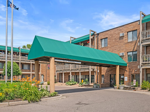 Entrance of a hotel featuring a green awning and brick architecture.