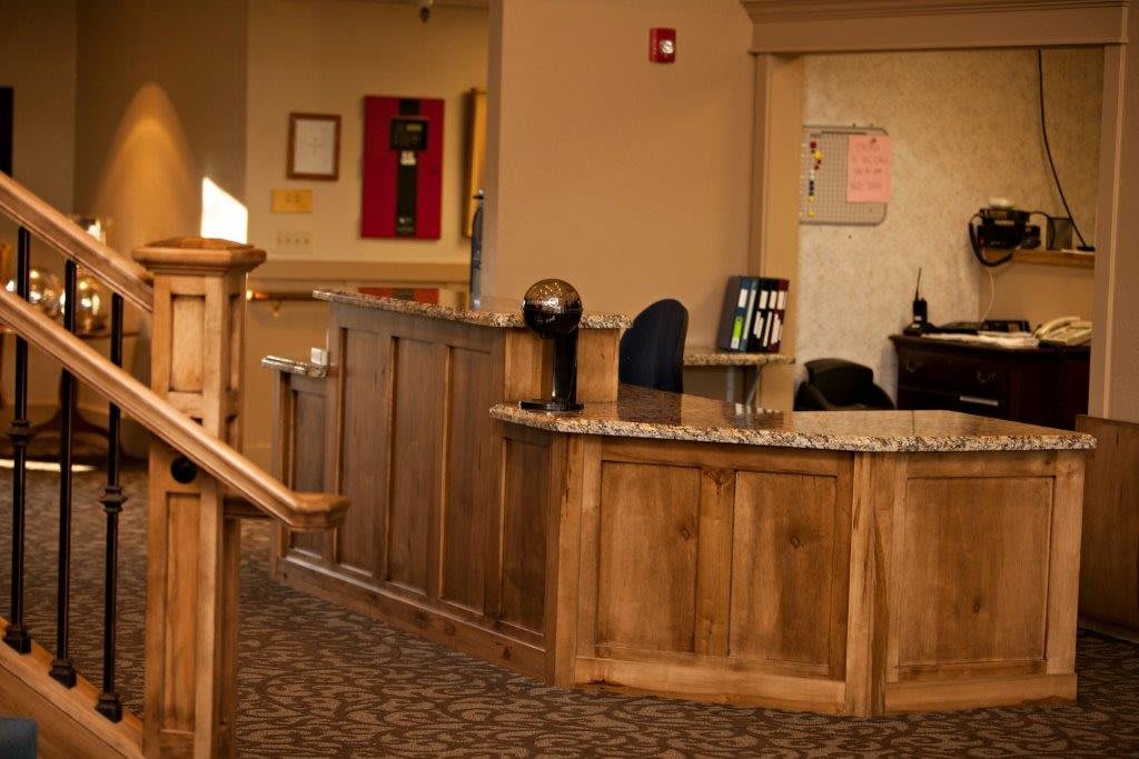 A hotel reception desk with a wooden counter and interior decor.