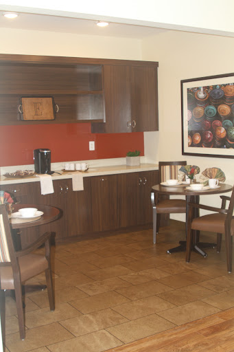 A cozy kitchen and dining area featuring modern wood cabinetry and a neatly set table.