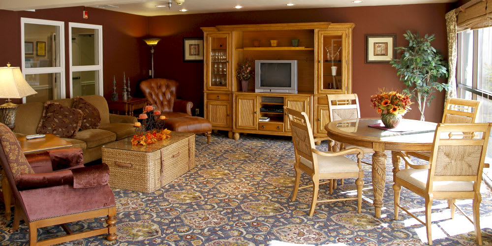 A cozy living room with wooden furniture and a patterned carpet.