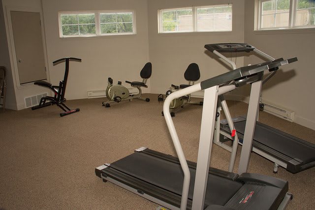 A small gym with exercise equipment including treadmills and stationary bikes.