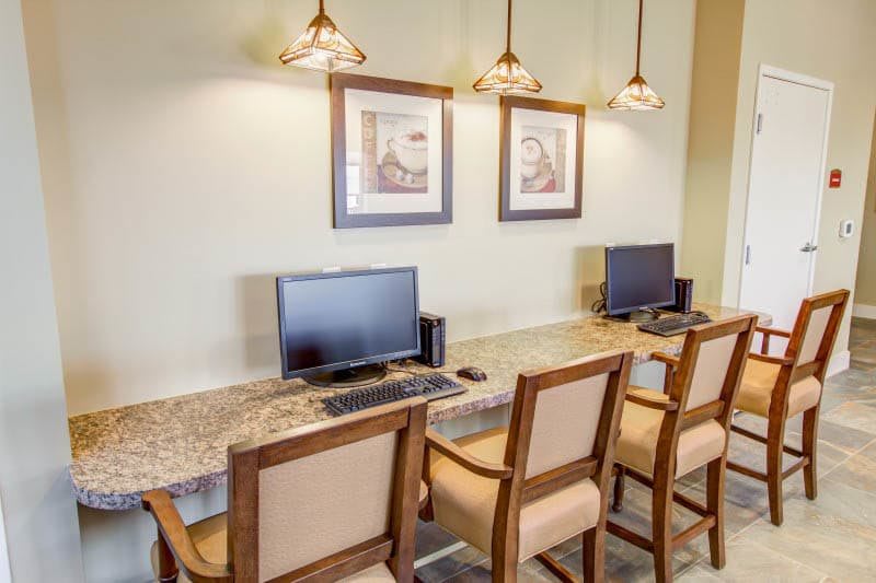A neatly arranged computer station with chairs and desktop computers in an office setting.