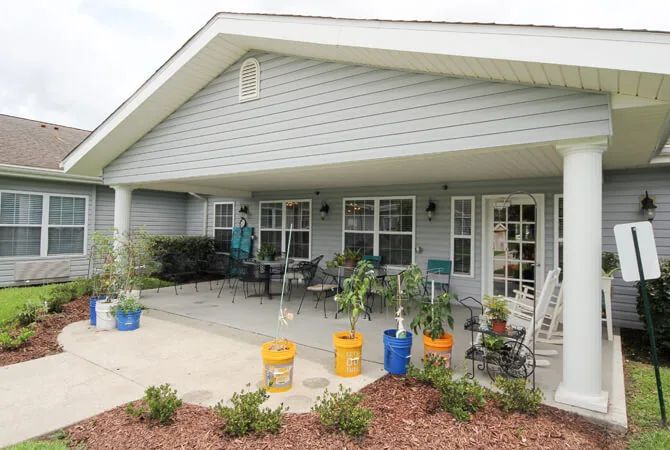 A cozy house with a spacious patio adorned with potted plants and outdoor seating.