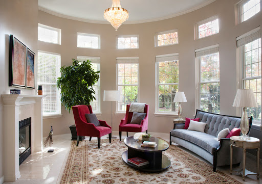 A beautifully designed living room featuring large windows, stylish furniture, and a touch of greenery.
