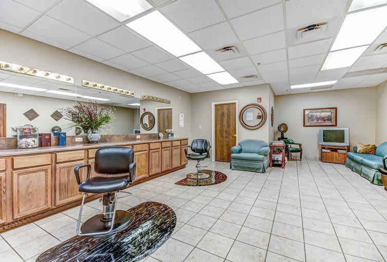 A well-lit salon interior with styling chairs, mirrors, and a cozy waiting area.