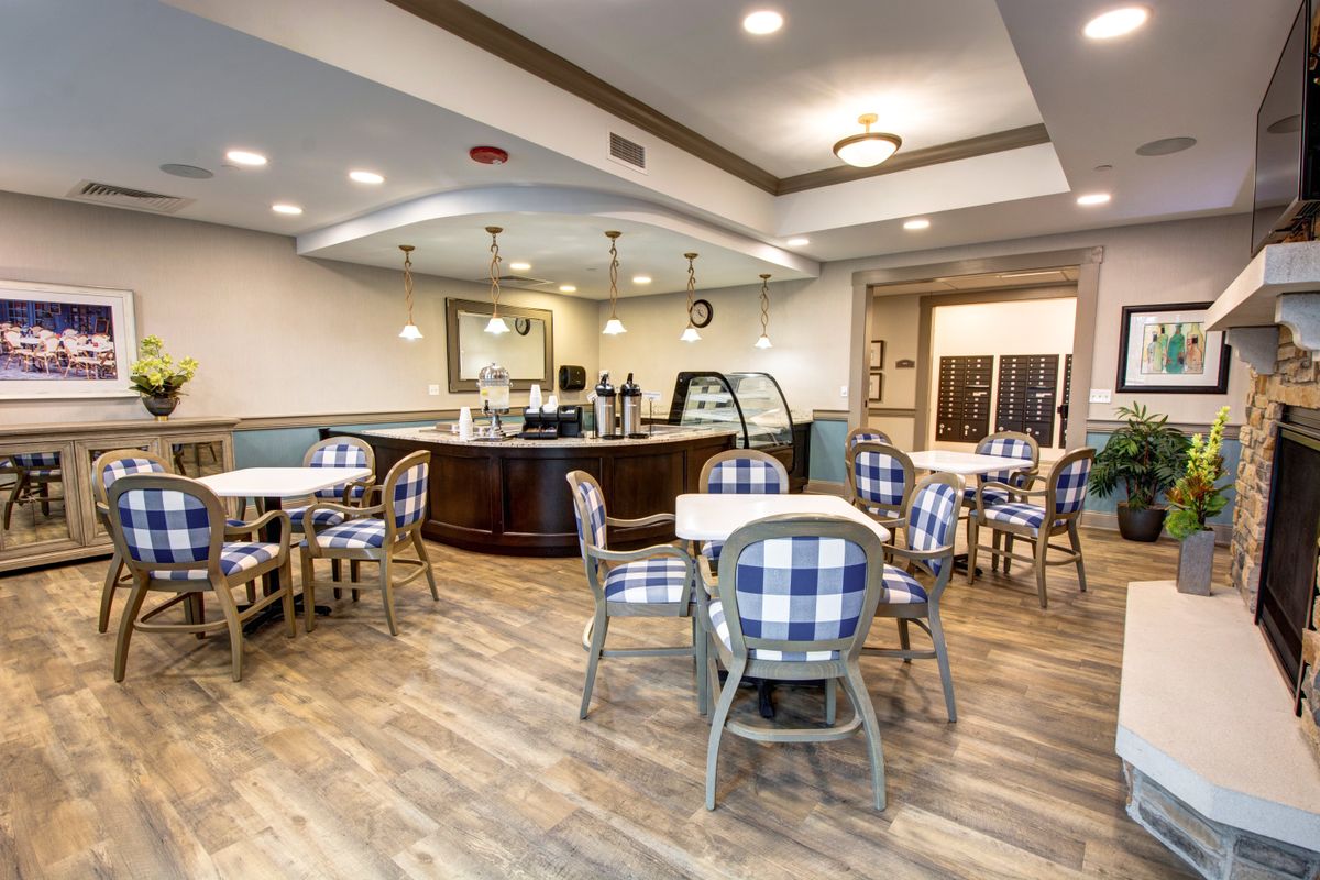 A cozy cafe interior with checkered chairs and wooden tables.