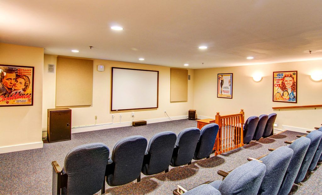 A cozy home theater with comfortable seating and a projector screen.