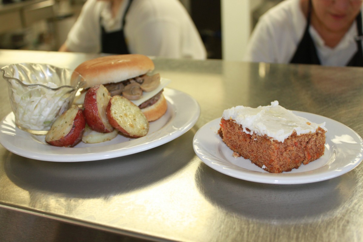 A sandwich with sliced potatoes and a piece of cake on plates.
