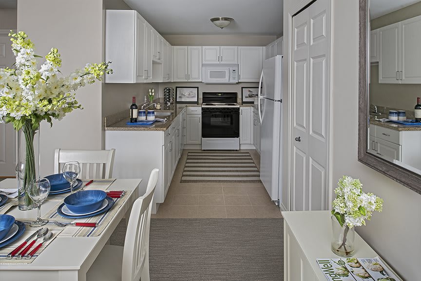 A modern and cozy kitchen with white cabinets and a small dining area.