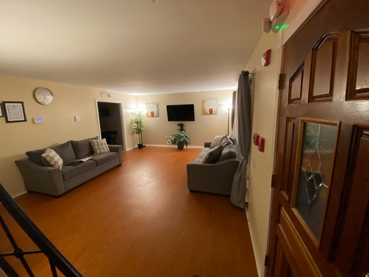 A cozy living room with sofas, a television, and warm lighting.