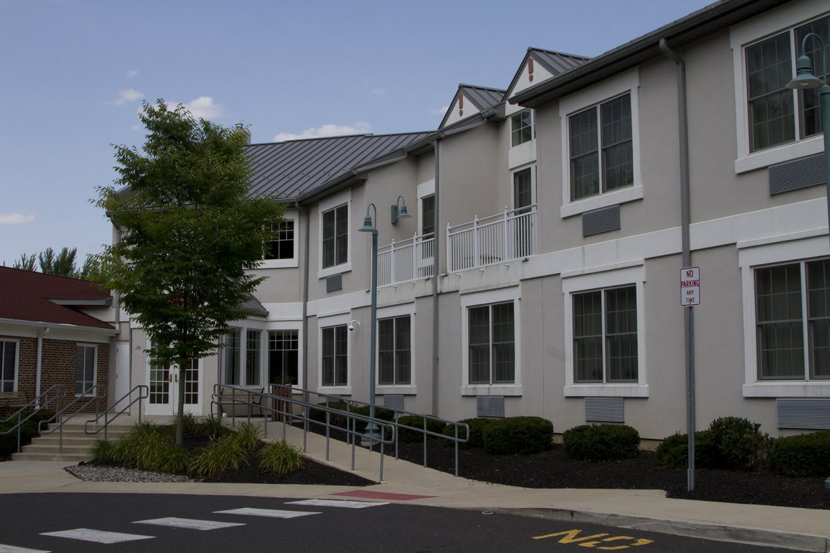 A modern residential building with a simple exterior design and surrounding greenery.